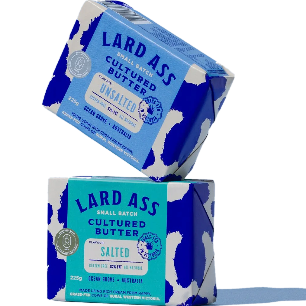 Two Lard Ass Small Batch Cultured Butter blocks stacked diagonally, one blue and one teal, on a clean white background with soft shadows.